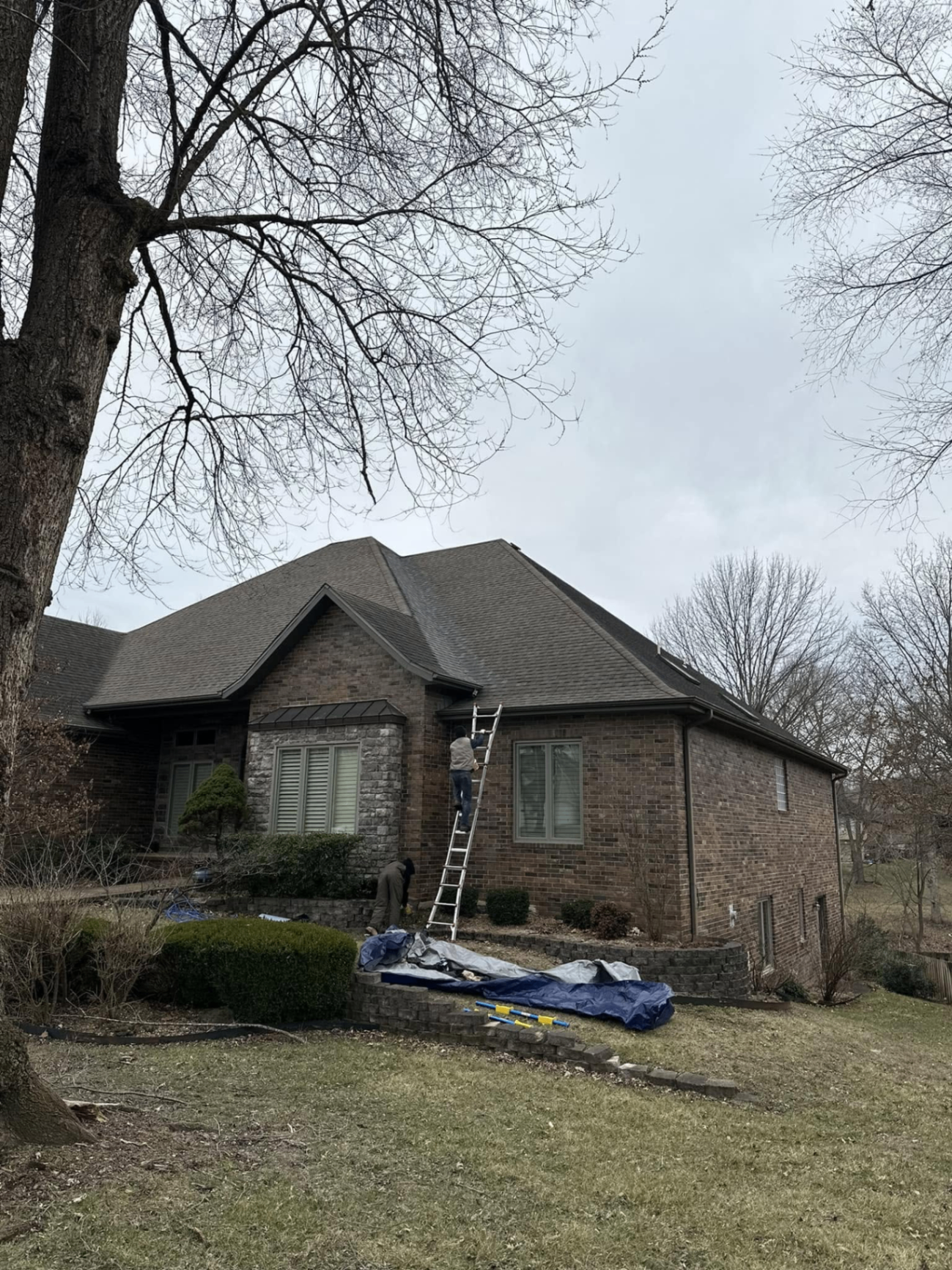 Storm-damaged roofing project inspection at a brick home